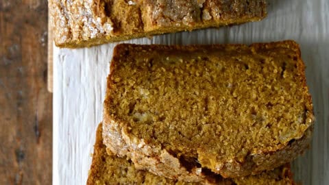 A loaf of pumpkin banana bread cut into thick slices.