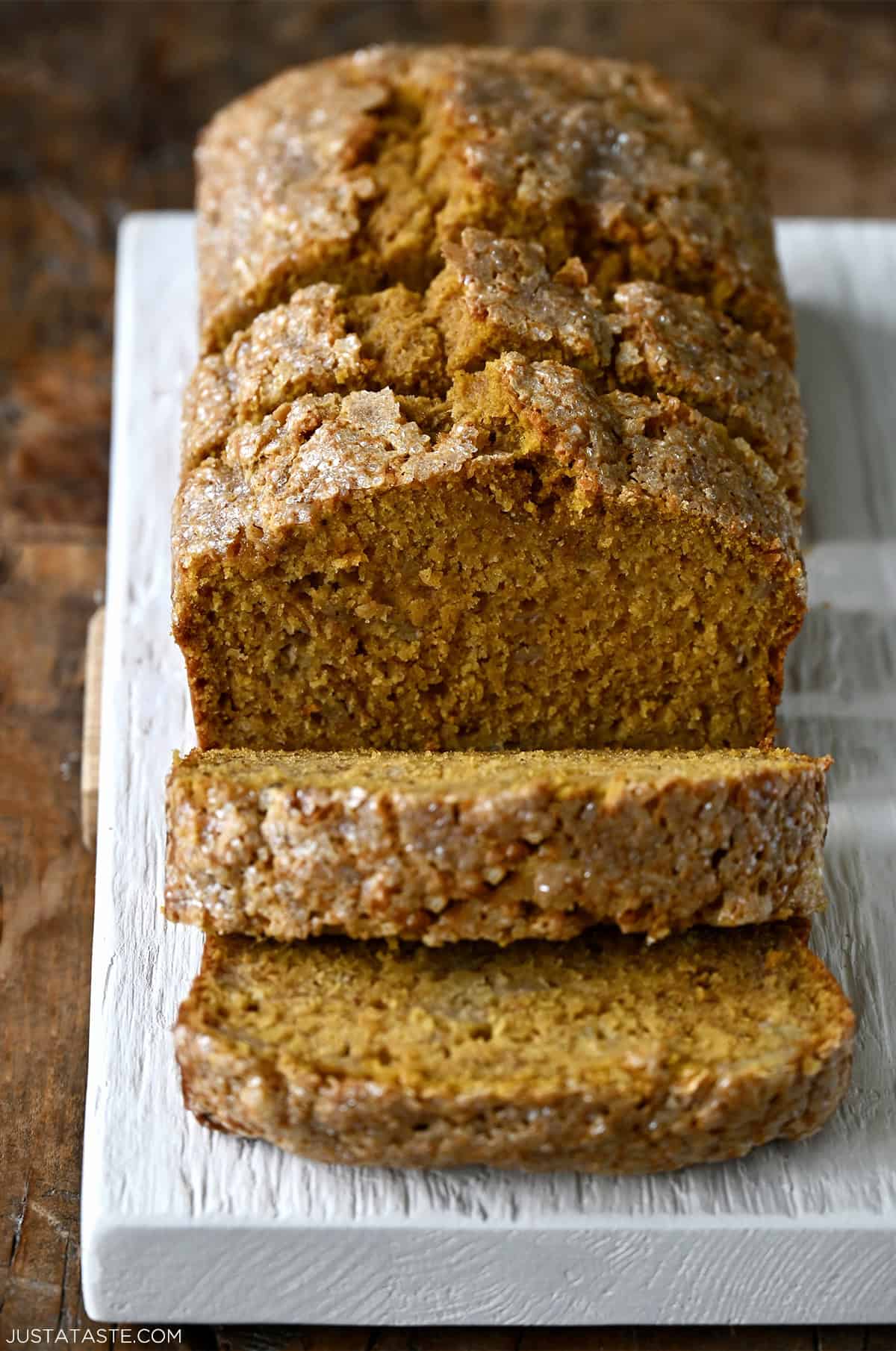 Pumpkin banana bread with a crunchy sanding sugar topping, cut into thick slices for serving.