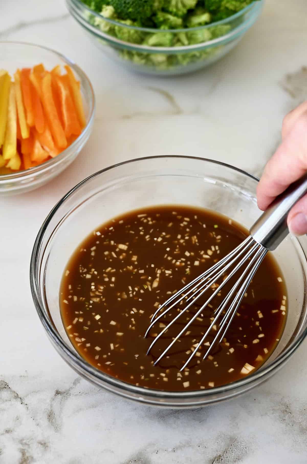 Whisking together a stir-fry sauce in a small bowl.