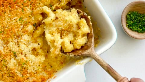 Creamy baked mac and cheese topped with golden breadcrumbs in a casserole dish.