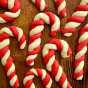 A top-down view of Classic Candy Cane Cookies on a wood surface above text that reads "Candy Cane Cookies" and the Just a Taste logo.
