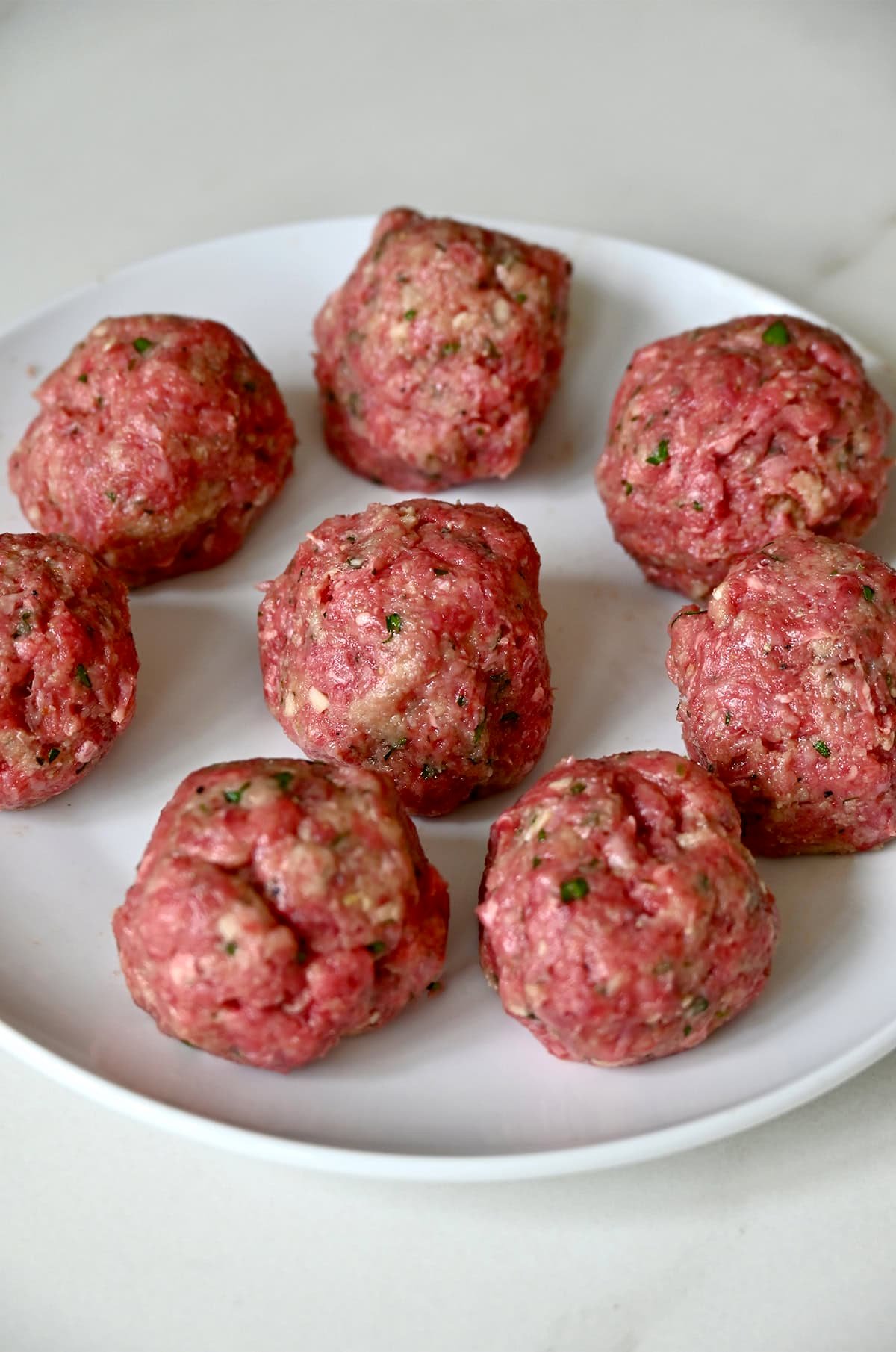 Cheese-stuffed meatball mixture formed into balls before cooking.