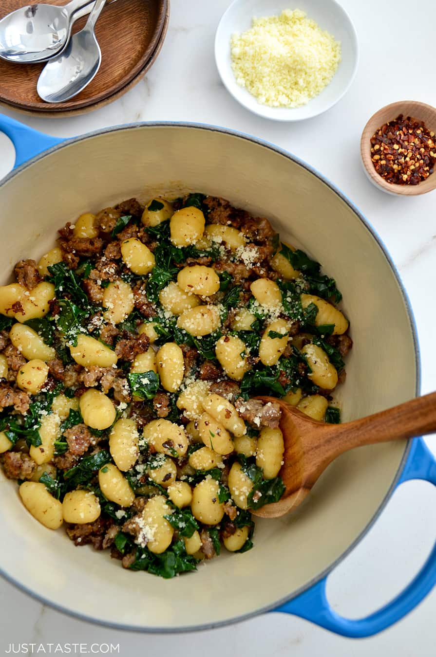 One-Pot Gnocchi with Sausage in a Dutch oven with a wooden spoon