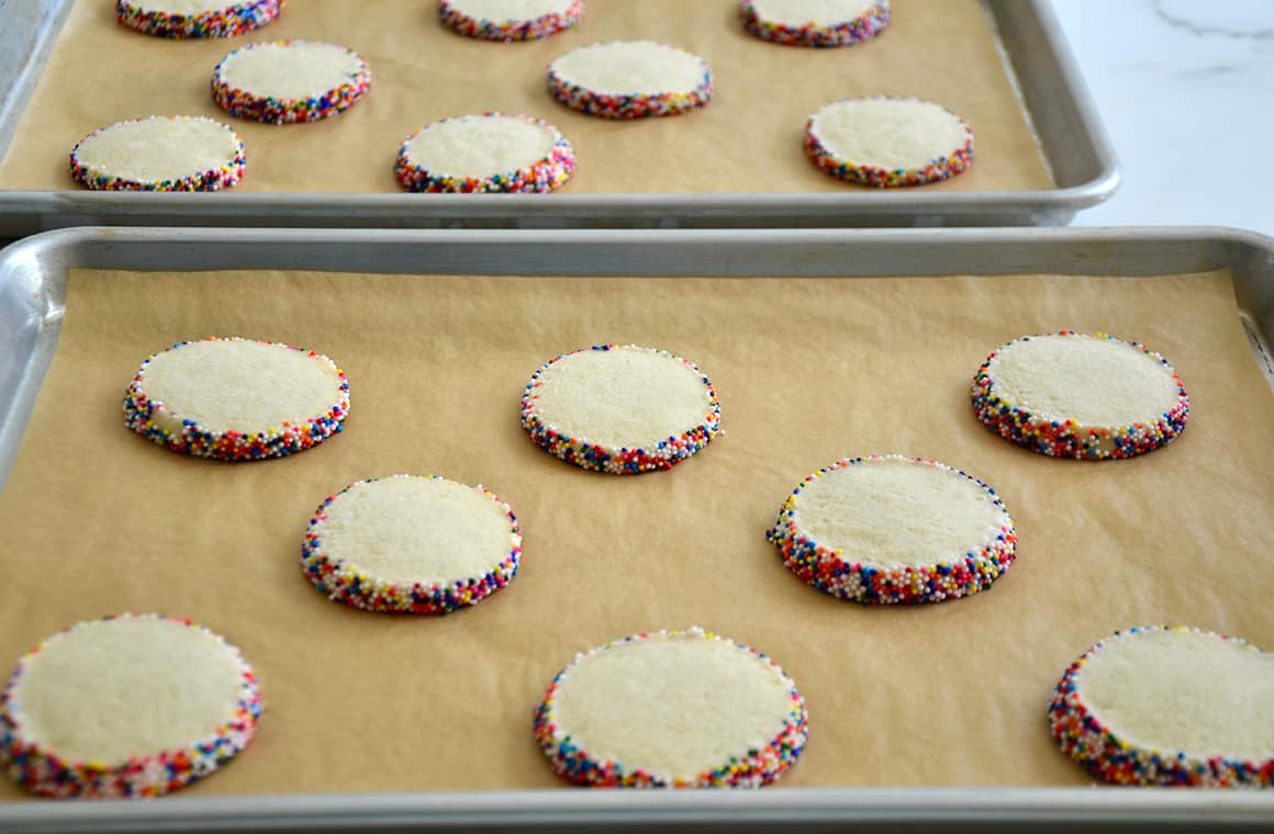 Unbaked sprinkle cookies on parchment paper-lined baking sheets