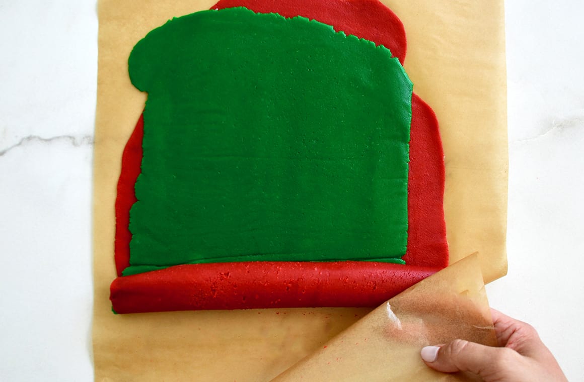 Green dough stacked atop red dough on parchment paper