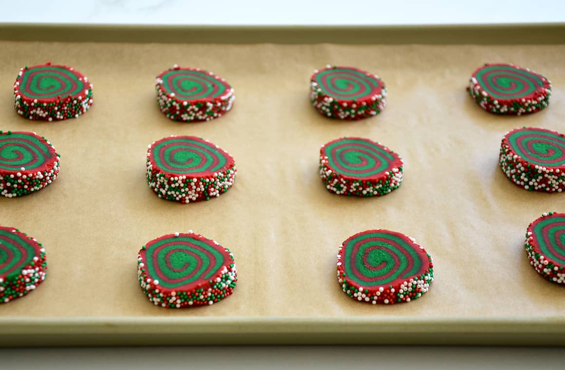 Unbaked Christmas cookies on a parchment paper-lined baking sheet