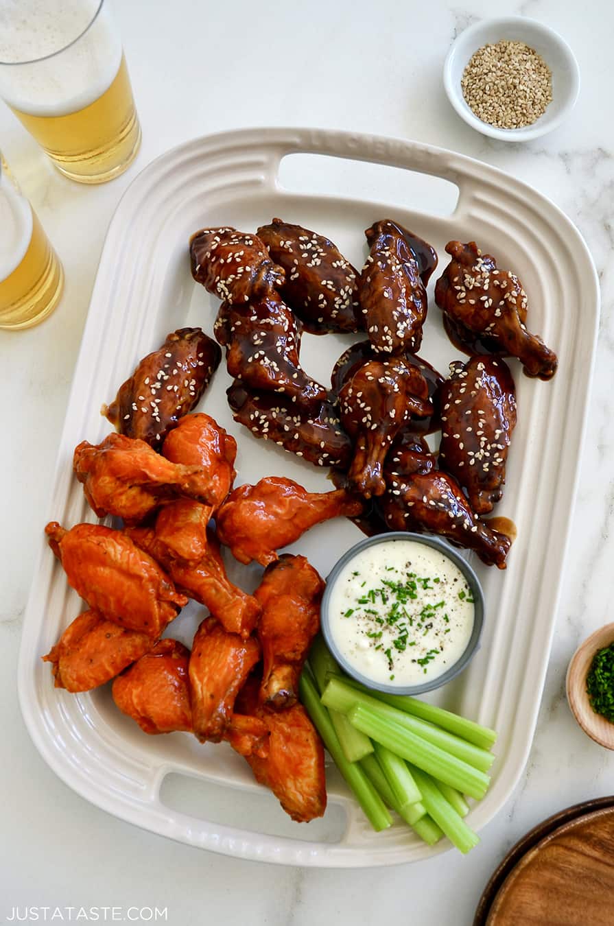 A large serving plate topped with Buffalo Air Fryer Chicken Wings and teriyaki Air Fryer Chicken Wings along with celery and ranch dipping sauce in a small ramekin 