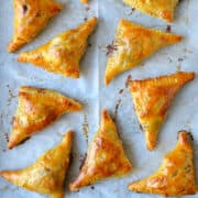 A top-down view of Baked Brie Bites with Jam atop parchment paper.