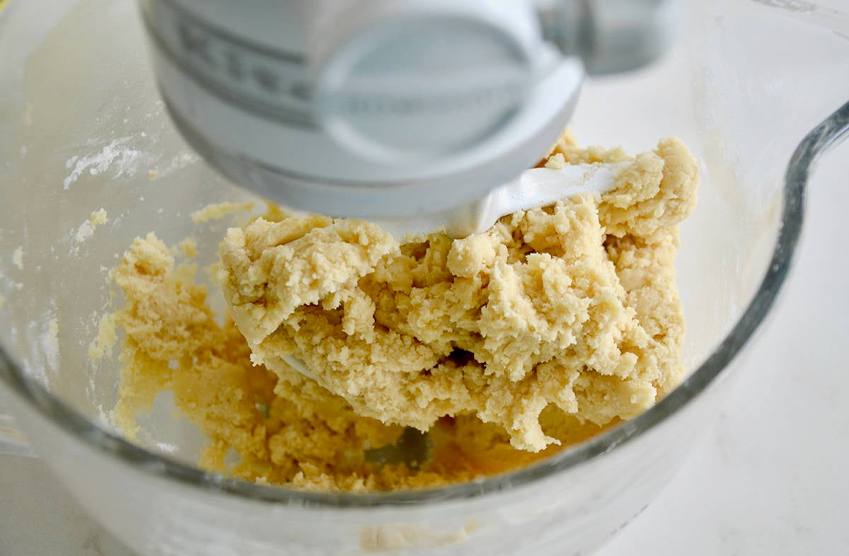 A white stand mixer with a clear bowl containing butter cookie dough.