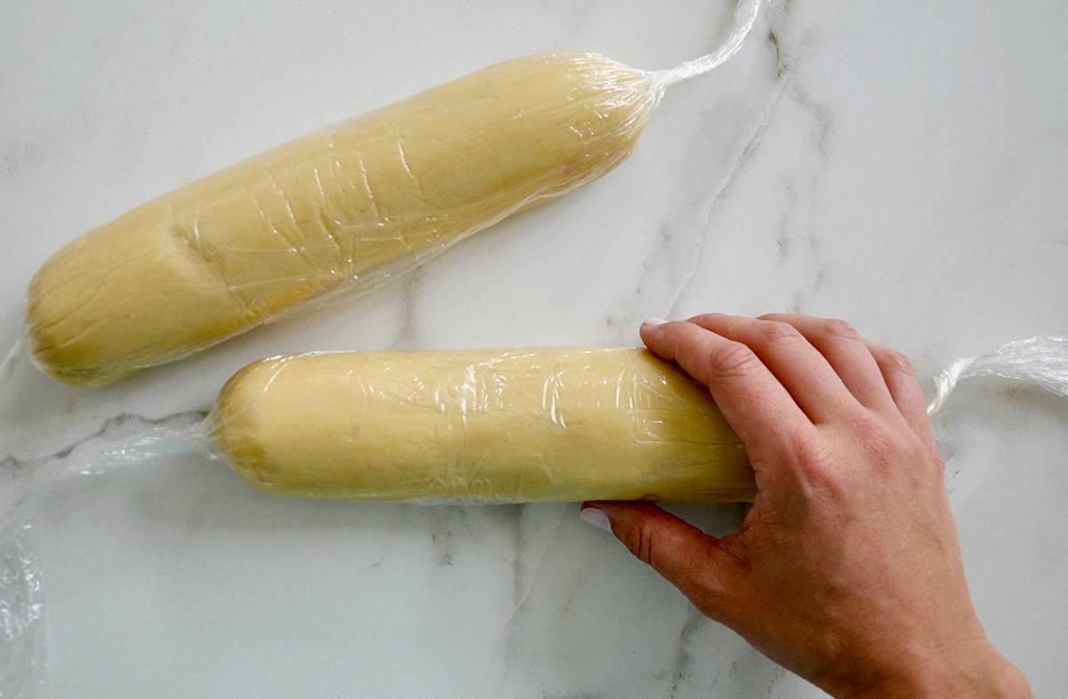 Two butter cookie logs wrapped in plastic wrap.