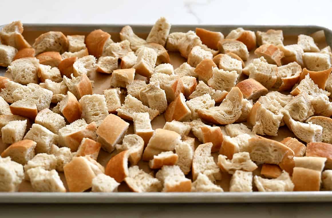 A baking sheet topped with dried bread cubes 