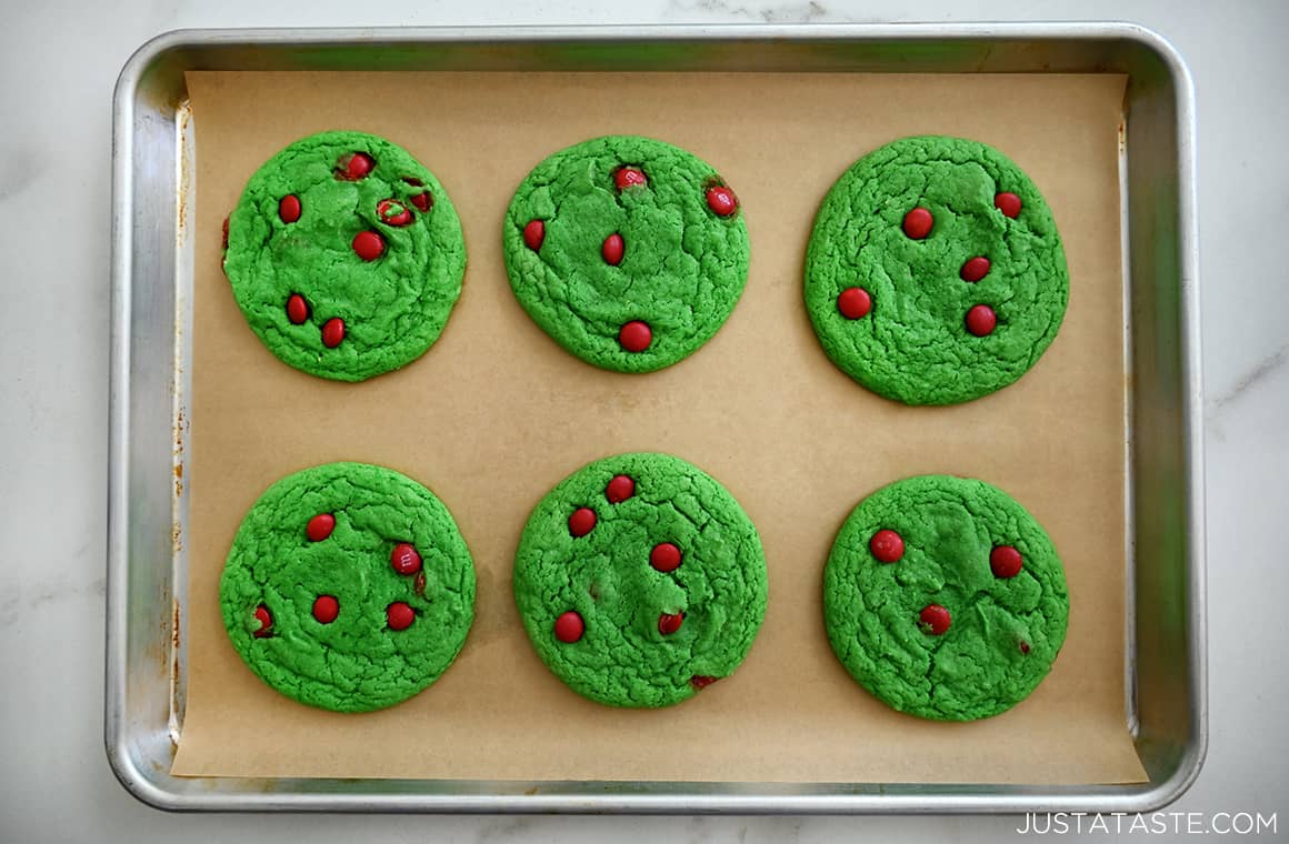A top-down view of Cake Mix Grinch Cookies atop a parchment paper-lined baking sheet