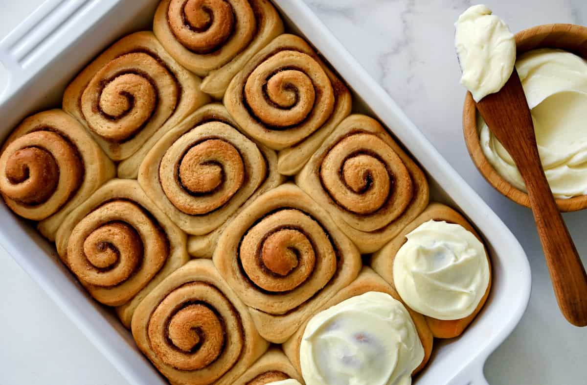 Homemade cinnamon rolls slathered with cream cheese frosting.