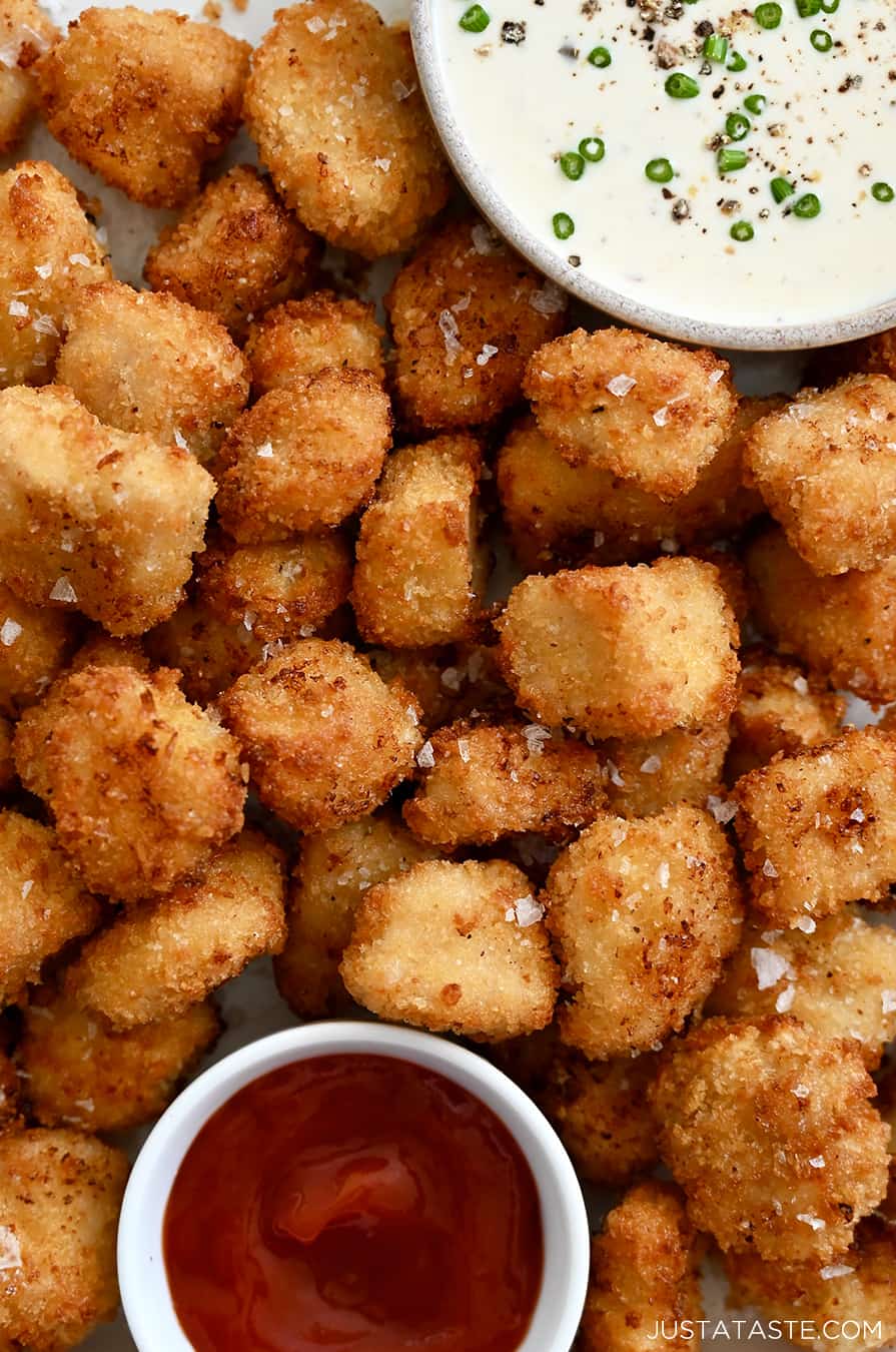 A close-up of chicken nuggets with ranch and ketchup