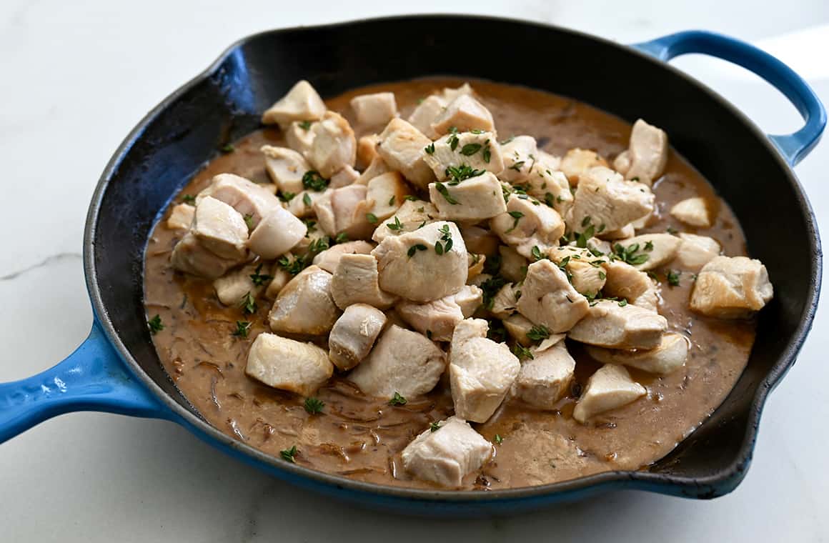 Chicken and caramelized onions in a blue skillet