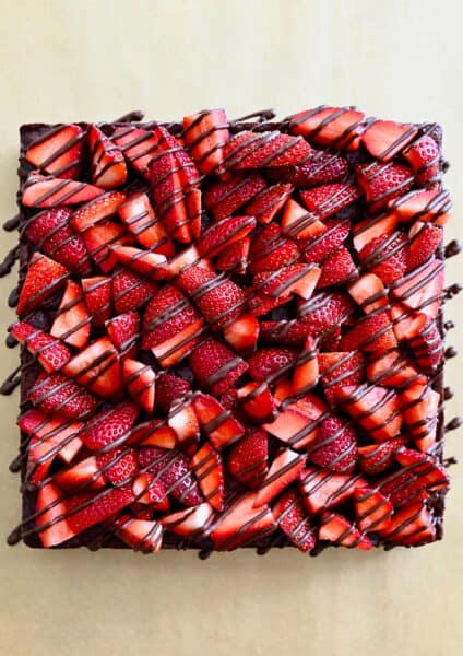 A top-down view of Chocolate-Covered Strawberry Brownies drizzled with chocolate