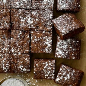 Cleanly cut brownies dusted with powdered sugar
