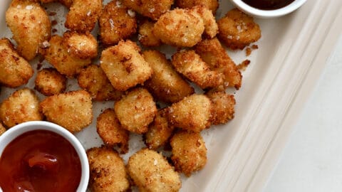 A top down view of a white platter containing chicken nuggets and two dipping sauces