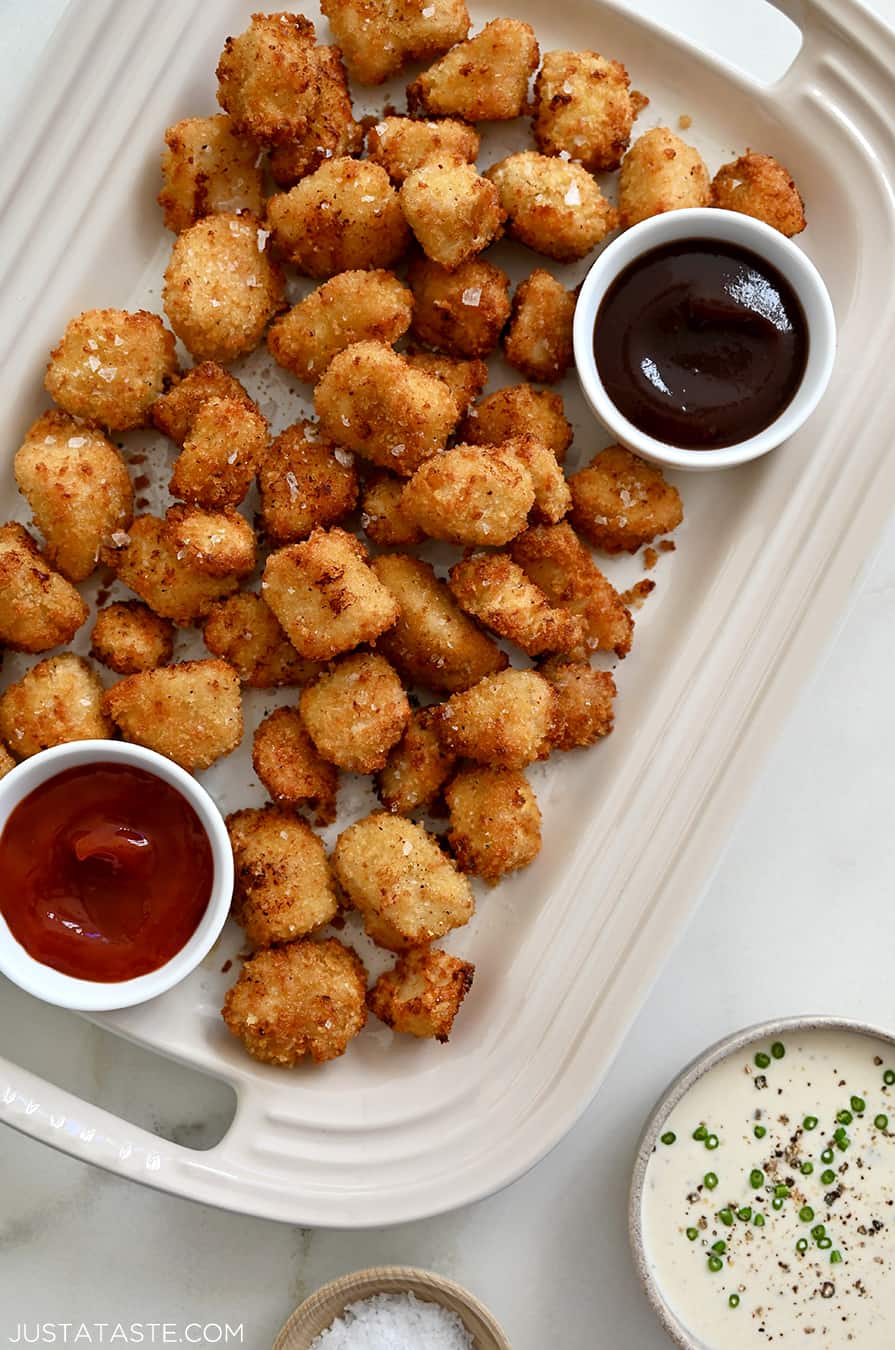 A top down view of a white platter containing chicken nuggets and two dipping sauces