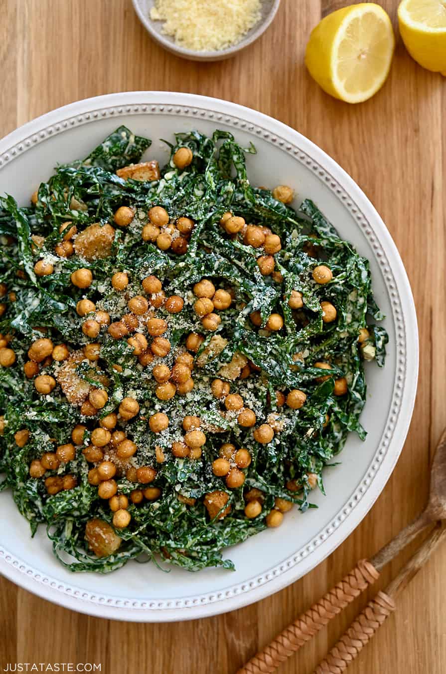 A top-down view of a white salad bowl with kale and chickpeas