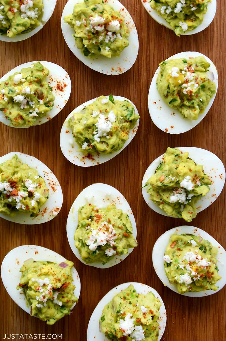 A close-up of guacamole deviled eggs on a wood background