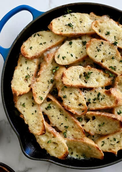 A top-down view of French Onion Chicken in a blue Le Creuset skillet