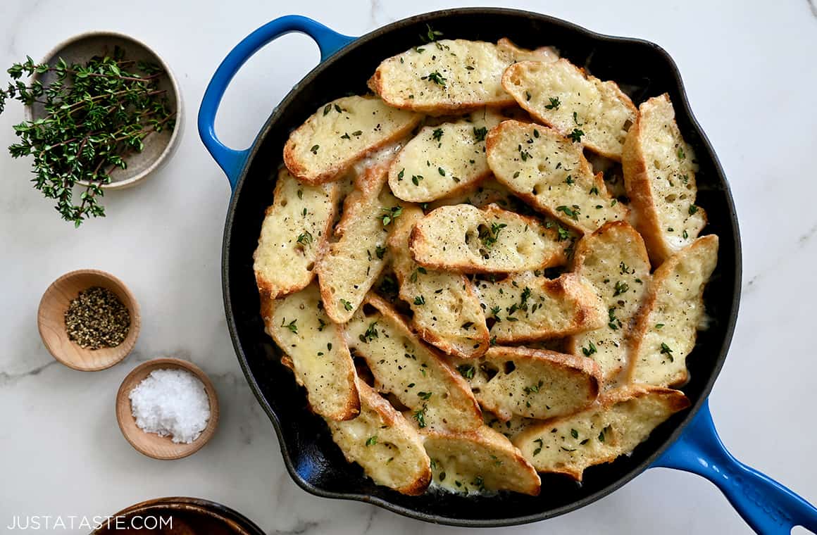 A top-down view of French Onion Chicken in a blue Le Creuset skillet