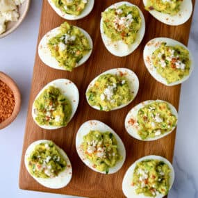 A top-down view of deviled eggs on a wooden platter