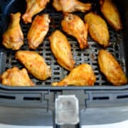 An air fryer basket with extra-crispy chicken wings above text that reads, "How to air fry chicken wings."