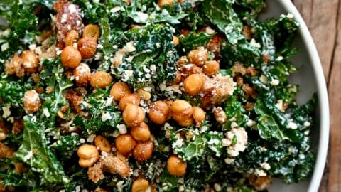 Tuscan kale Caesar salad with homemade croutons and crispy chickpeas in a large serving bowl.