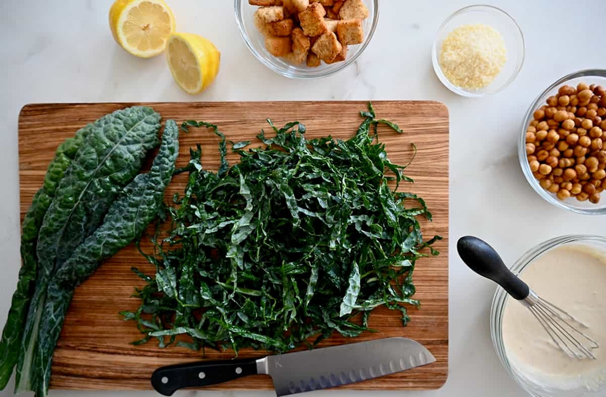 Lacinato kale cut into thin ribbons on a cutting board.