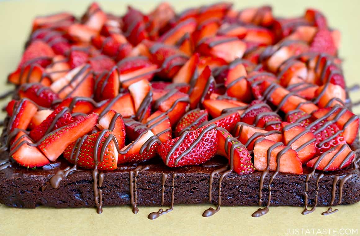 The best fudge brownies topped with sliced strawberries drizzled with chocolate 