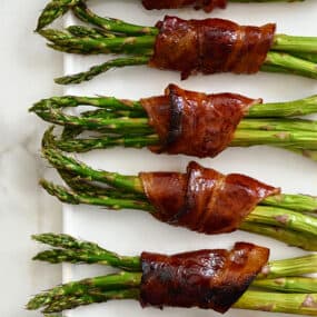 Crispy Bacon-Wrapped Asparagus Bundles on a white serving plate