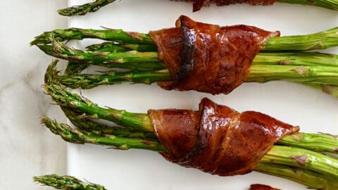 Crispy Bacon-Wrapped Asparagus Bundles on a white serving plate