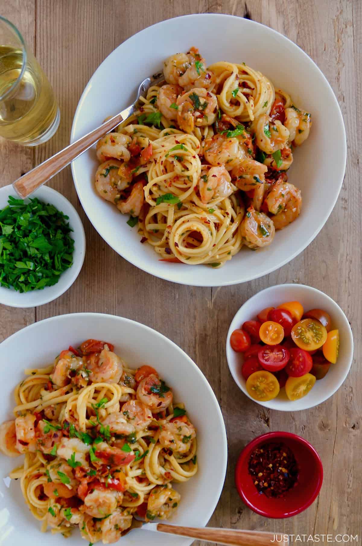 Two bowls containing shrimp scampi pasta with cherry tomatoes.