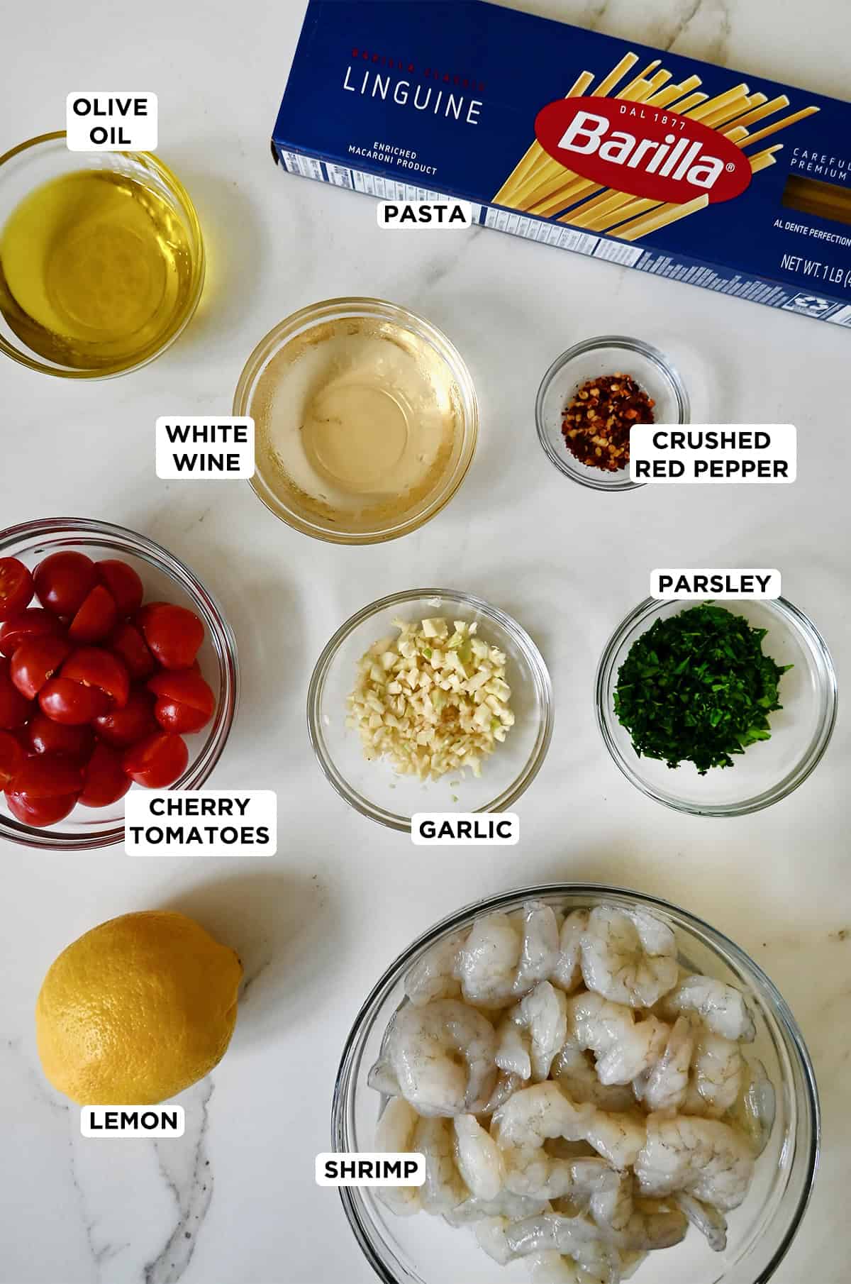 Ingredients to make shrimp scampi with pasta and cherry tomatoes.