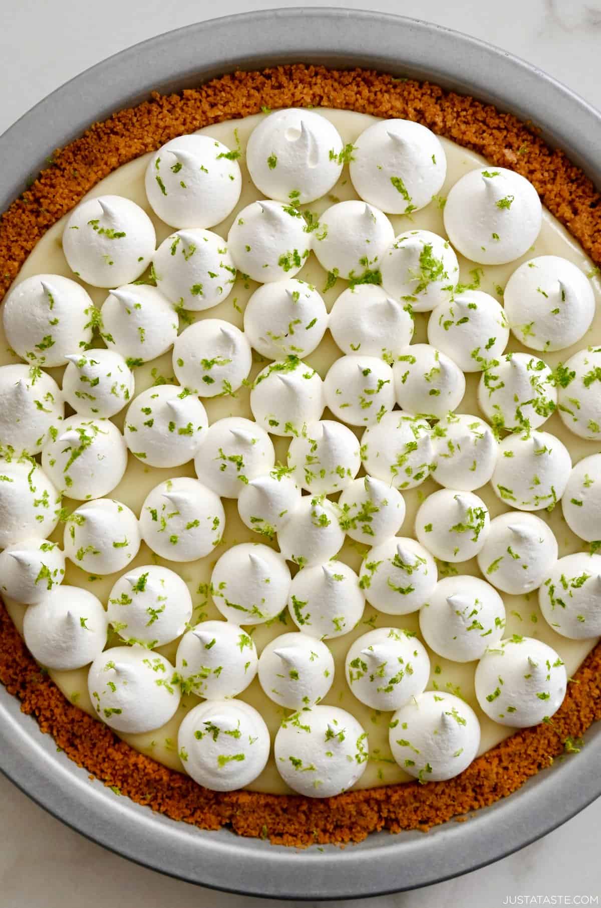 Homemade key lime pie topped with whipped cream and lime zest.