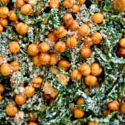 A close-up of shredded kale salad topped with grated Parmesan cheese.