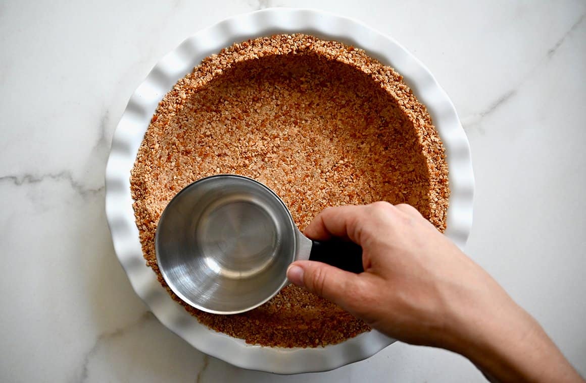 A white pie plate with a pretzel crust