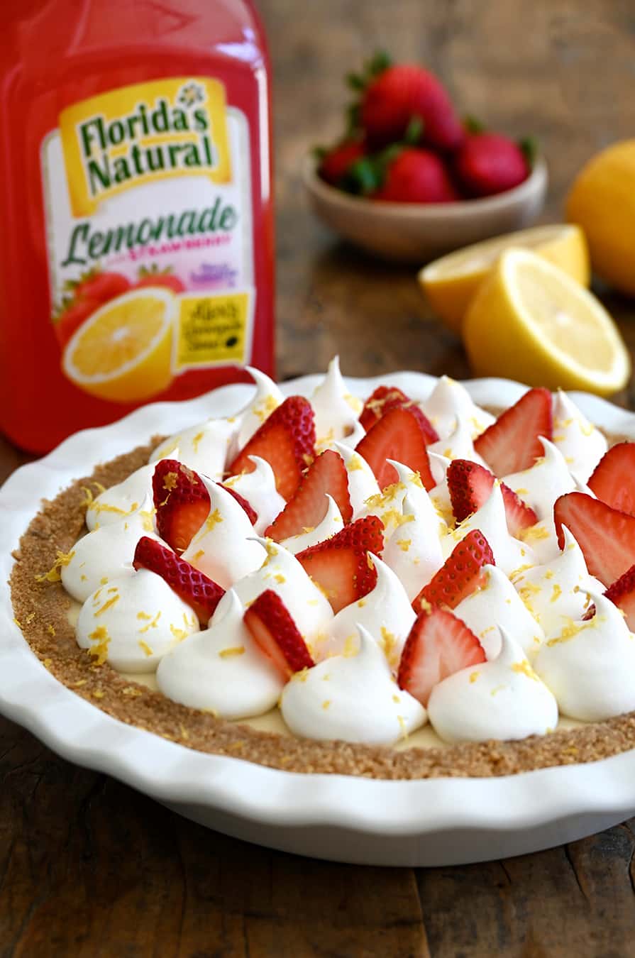 A strawberry lemon icebox pie with a bottle of lemonade in the background