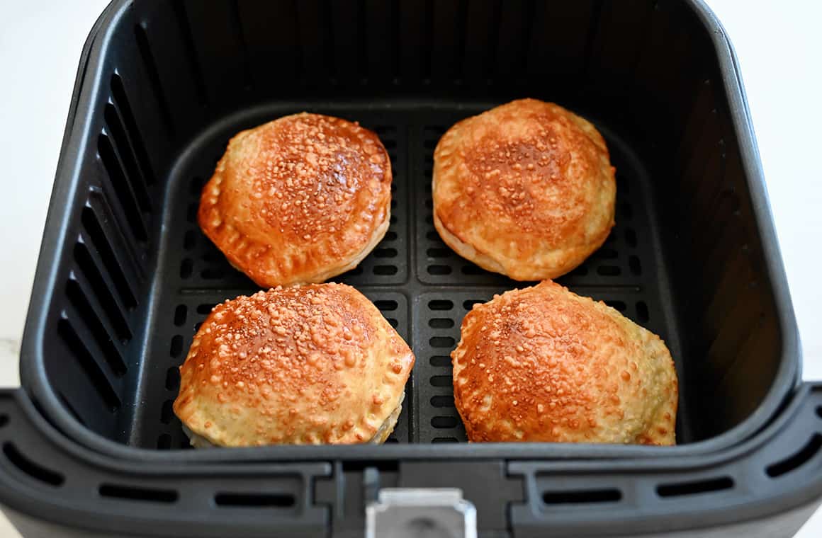Four pizza pockets in an air fryer basket