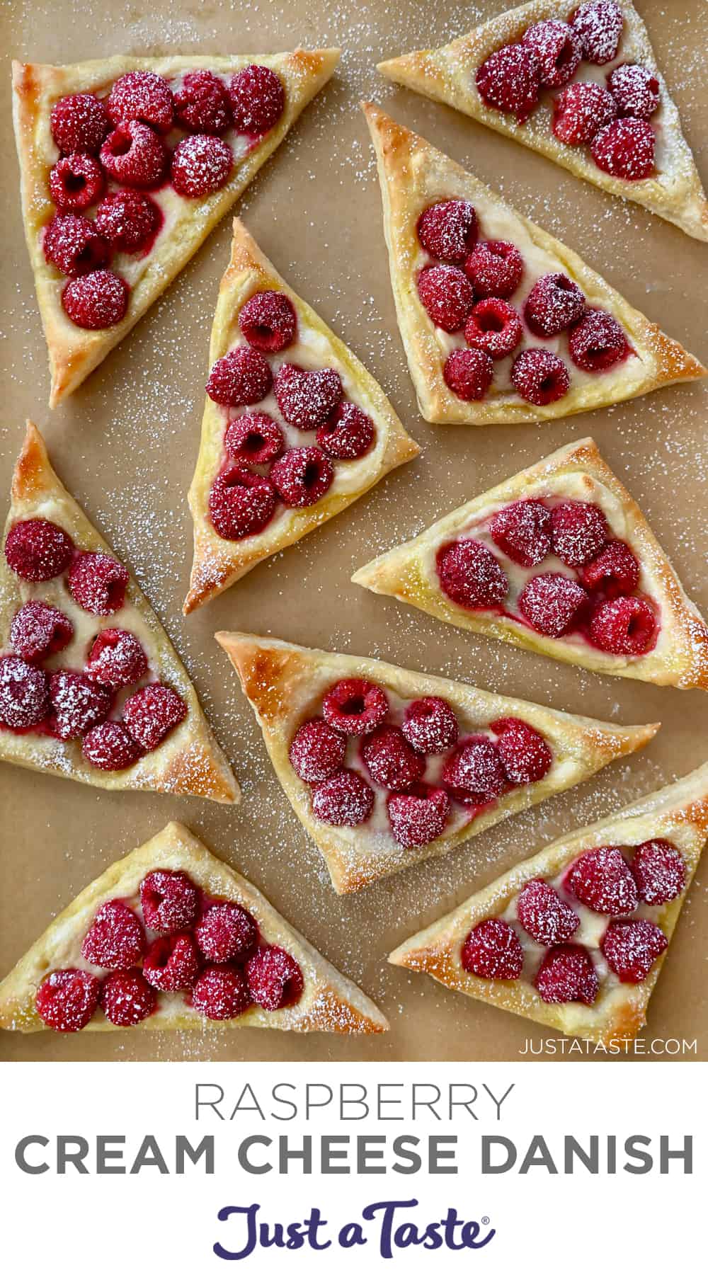 A top-down view of Cream Cheese Danishes topped with fresh raspberries and dusted with powdered sugar.