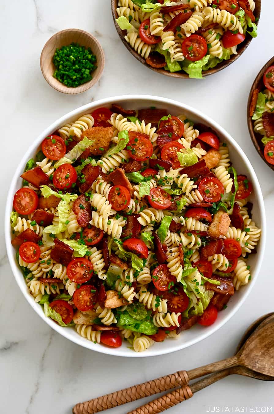 30-Minute BLT Pasta Salad in a large white serving bowl next to wooden serving spoons