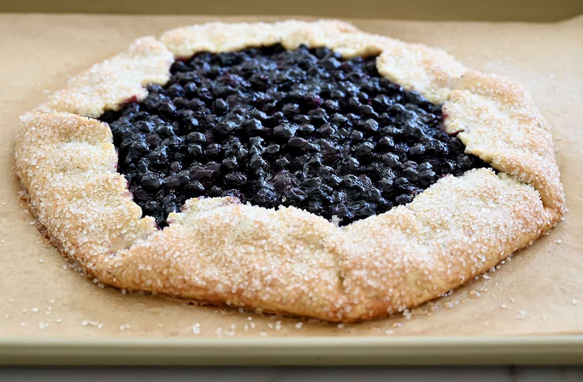 A freshly baked berry galette on a parchment paper-lined baking sheet