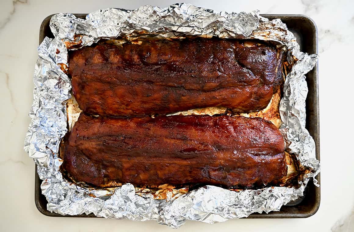 Barbecue ribs atop a foil-lined baking sheet