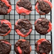 A top-down view of swirled raspberry cheesecake brownie bites on a wire cooling rack.