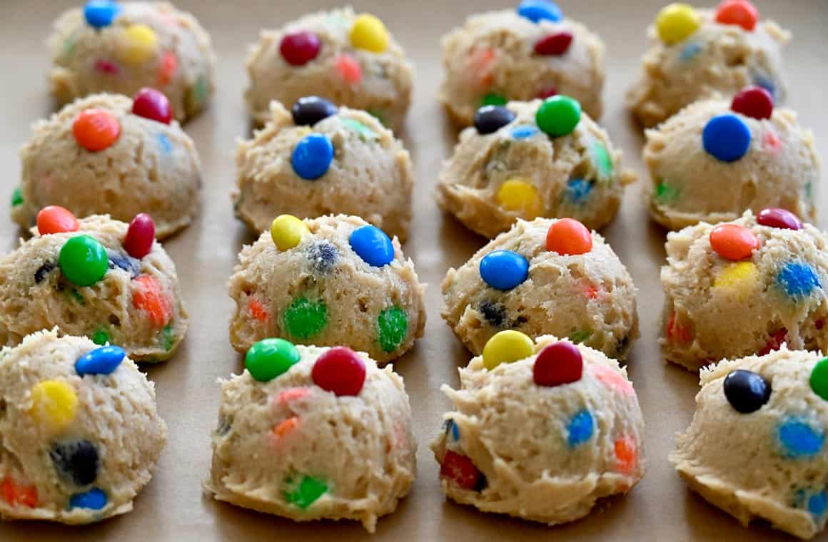 Rows of perfectly scooped cookies studded with M&Ms