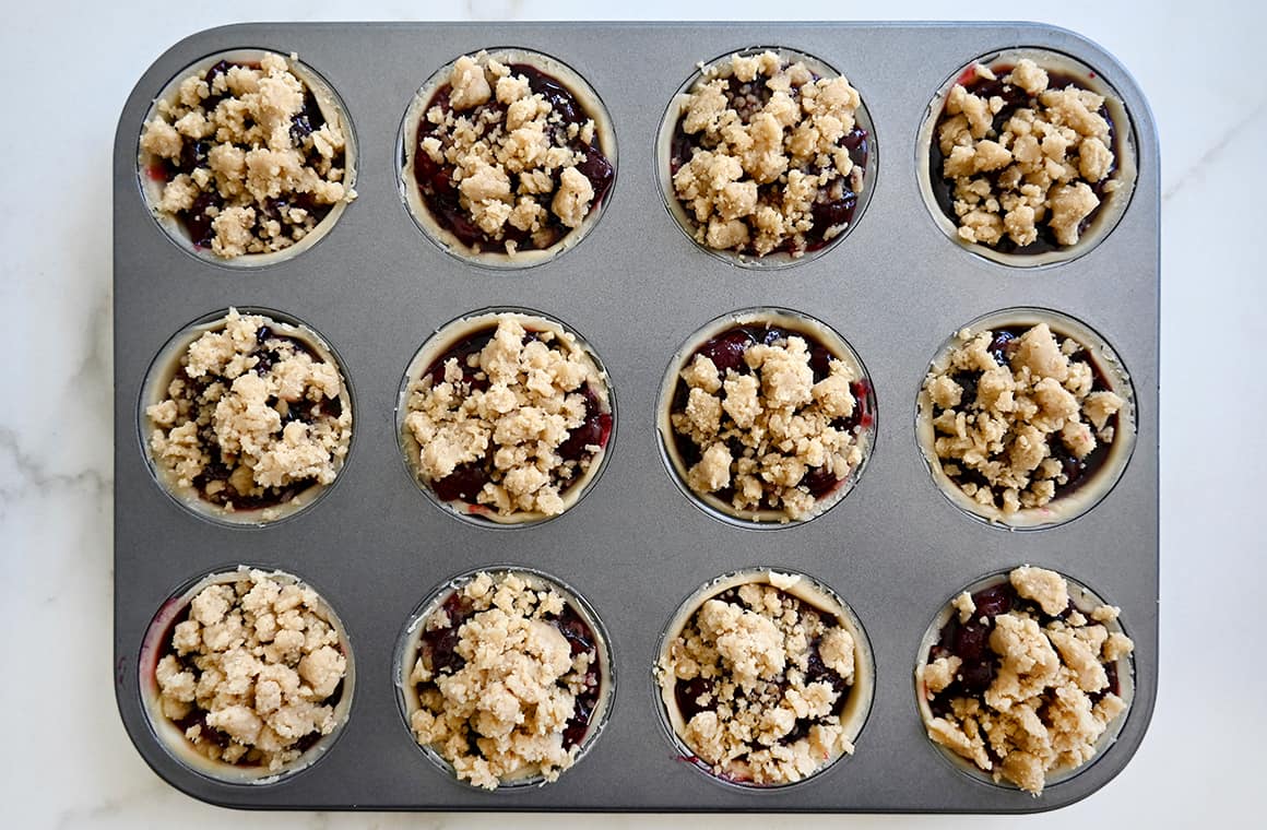 A top-down view of unbaked mini muffin pan pies