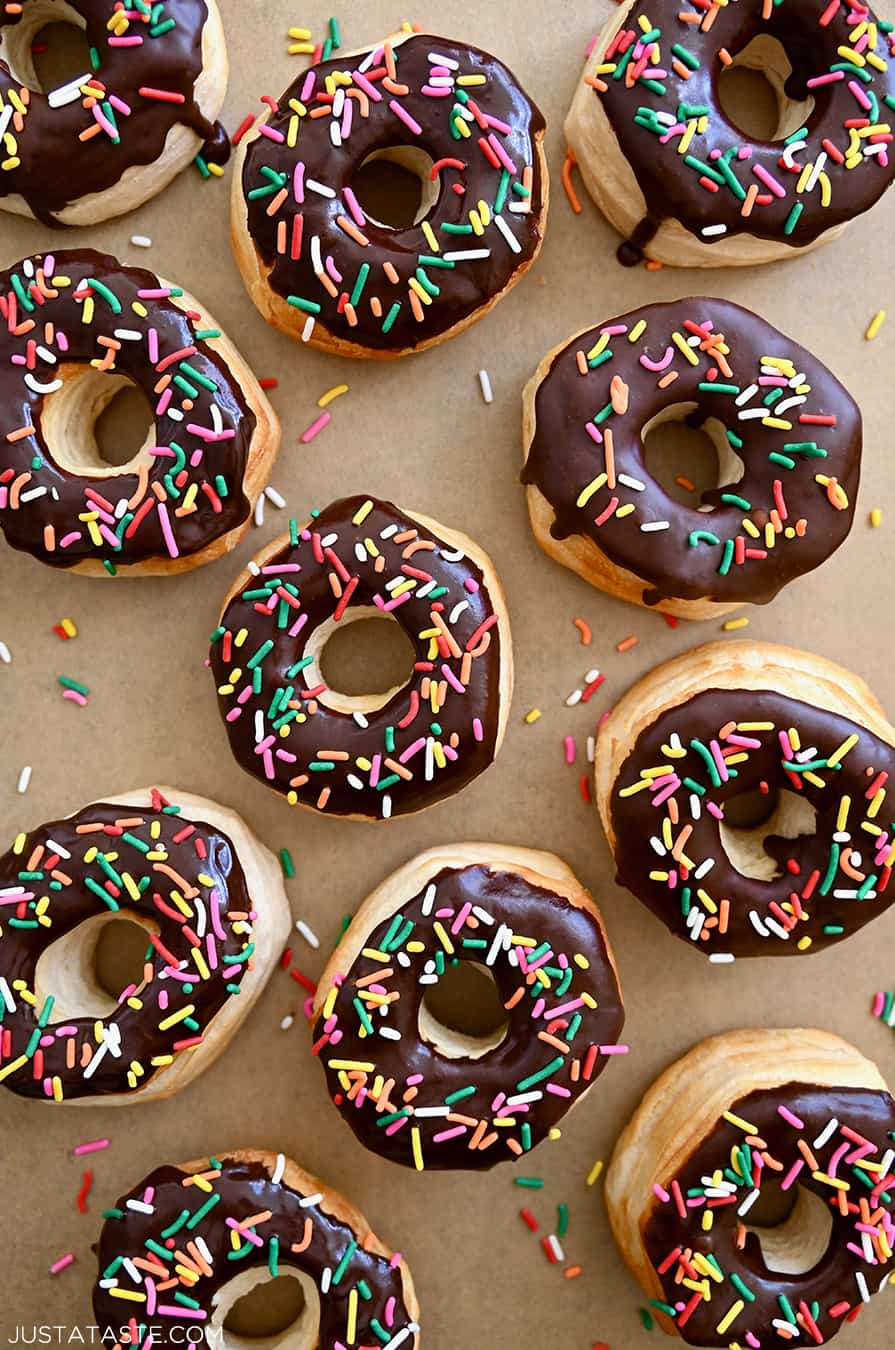 A top-down view of Air Fryer Biscuit Doughnuts topped with chocolate glaze and rainbow sprinkles