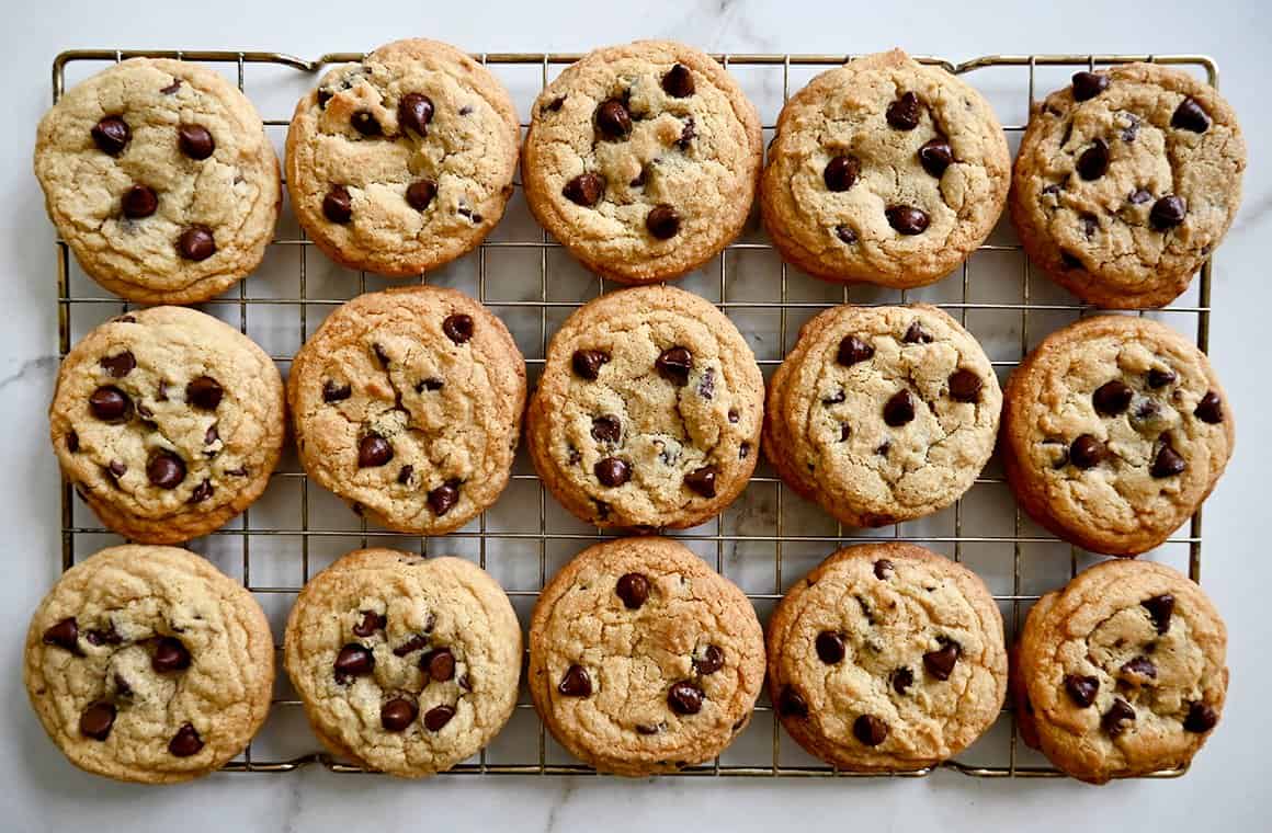 A top-down view of baked chocolate chip cookies resting on a cooling rack